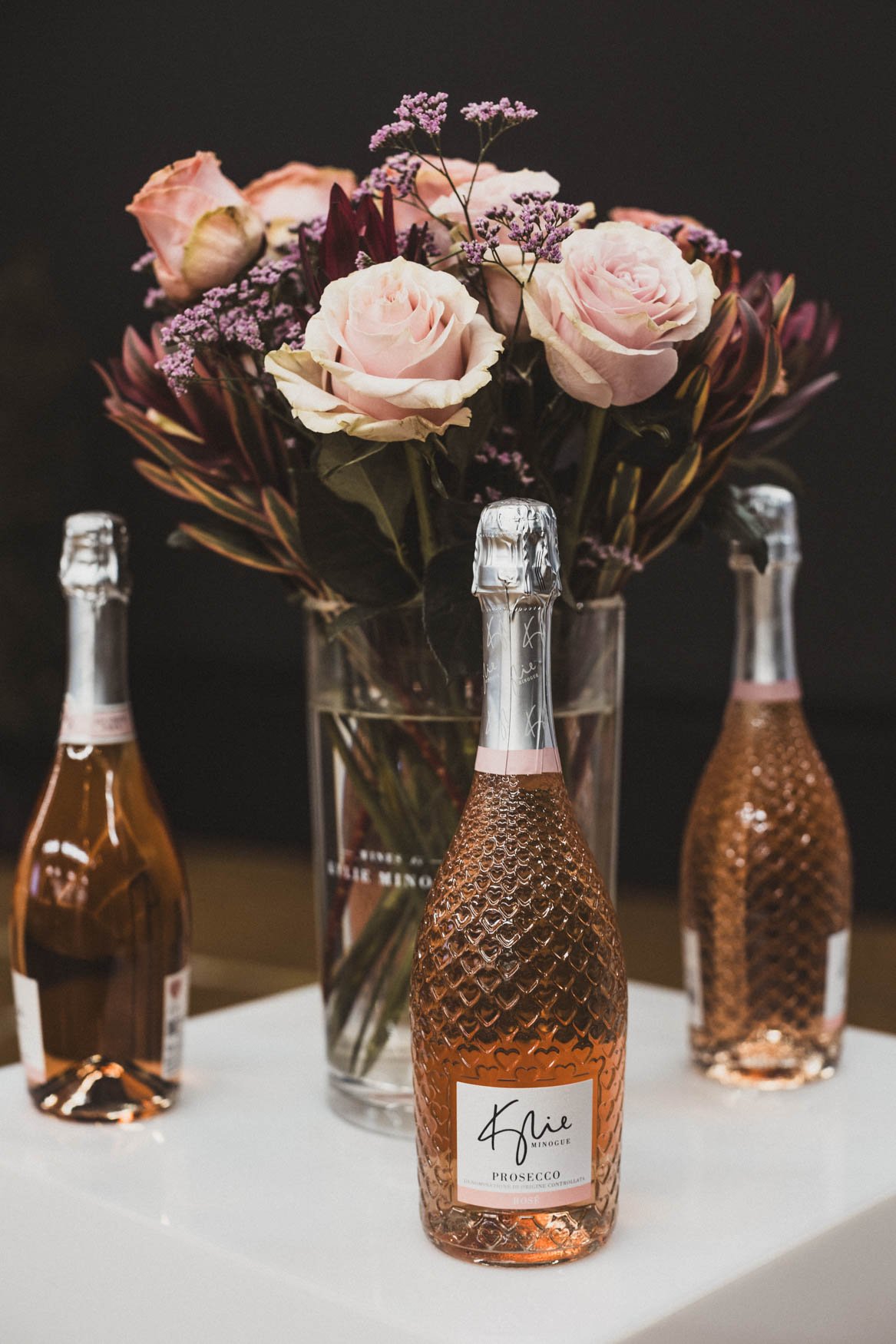 Kylie Prosecco Alkoholfrei Flaschen vor Blumenstrauss